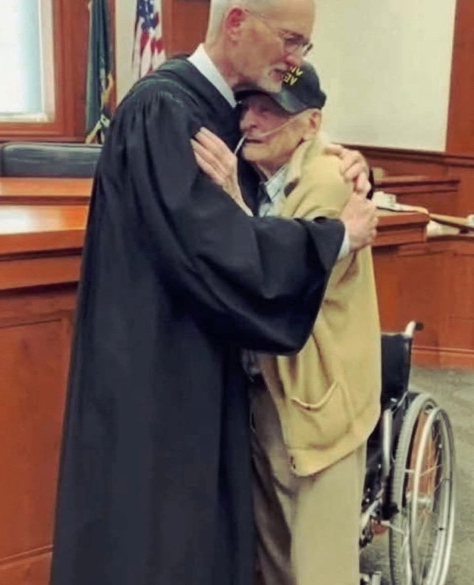 Arthur Harris, vietnámi veterán, 88 éves.A bírósági terem hátsó sorában ült, tolószékében.Reszkető kezében tartotta azokat a papírokat,amelyek elvehették tőle az utolsó dolgot, ami még az övé volt: az otthonát.Felesége már évekkel ezelőtt meghalt.Gyermekei sosem születtek.A ház falai lassan omlottak szét –akárcsak az ő teste, akárcsak az ő élete.A város sorra küldte a bírságokat:repedezett tornácért, lepattogzott festékért, beázó tetőért.Tartozások, amiket nem tudott kifizetni.Most ott ült a bíró előtt,aki híres volt szigoráról és a törvény könyörtelen betűjének követéséről.A város ügyvédje kérte: engedélyezzék a ház elvételét.Ez volt a vég.Arthur lehajtotta a fejét –és hosszú évtizedek óta először sírni kezdett.A terem elnémult.A bíró keze megállt a levegőben, mielőtt lecsapta volna a kalapácsot.Hangja, amely mindig hideg és határozott volt, most megremegett:— Tizenöt perc szünetet rendelek el.Amikor visszatért, valami megváltozott benne.Már nem egy bíró beszélt — hanem egy ember.— Harris úr — szólalt meg halkan —,épp most beszéltem a veteránügyek hivatalával és a megyei alappal.Minden bírságát eltörölték.Arthur hitetlenkedve emelte fel a fejét.— És még valami — folytatta a bíró. —Egy építőipari szakszervezet vállalta,hogy ingyen felújítják a házát.Már a jövő héten elkezdik.Az öreg férfi sírva fakadt —de most először nem félelemből,hanem megkönnyebbülésből.És ekkor történt valami, amit senki sem várt.A bíró felállt, lejött a pulpitus mögül,odament a tolószékhez,és átölelte Arthurt.Egy hosszú, őszinte, emberi ölelés volt, minden hivataloskodás nélkül.Arthur, könnyein át, csak ennyit tudott suttogni:— Azt hittem… már senkinek sem számítok.A bíró megszorította a vállát, és elcsukló hangon felelte:— Számít. Maga szolgált minket. Nem felejtettük el.Aznap, abban a bírósági teremben,a jog arca emberi lett —és a hála újra megszólalt.