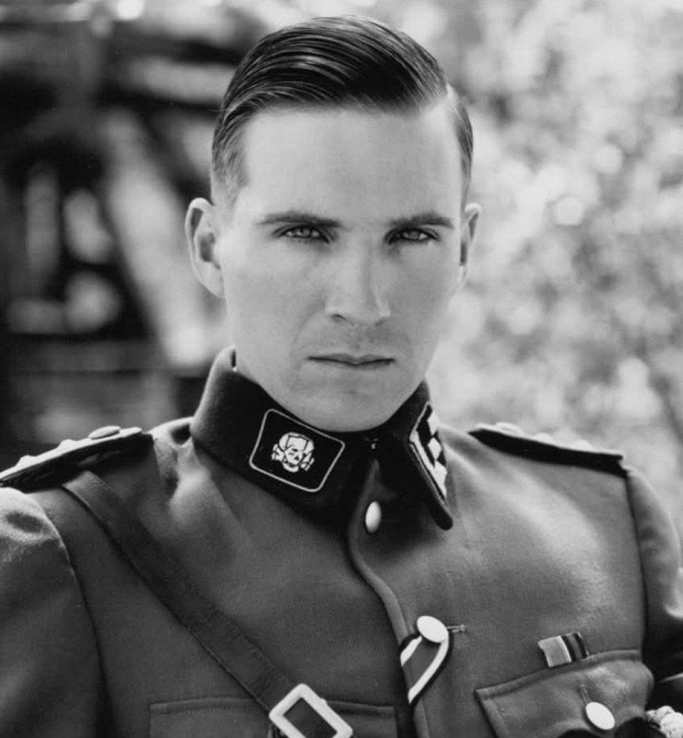 Amikor Ralph Fiennes 1992-ben megjelent a Schindler listája meghallgatásán, senki sem sejtette, mi fog történni, még Steven Spielberg sem. Fiennes akkor még egy visszafogott, brit színházi színész volt, Shakespeare-szerepeiről ismert, semmi fenyegető nem volt benne.Csendes, udvarias és precíz emberként lépett be a szobába. De amikor elkezdte felolvasni a náci parancsnok, Amon Goeth szövegét, valami megváltozott. A légzése lelassult, a tekintete megkeményedett, és mintha a levegő is megfagyott volna körülötte. Spielberg ledermedt. Amikor a jelenet véget ért, nem szólt semmit, csak felállt és kiment a teremből.Néhány perc múlva visszatért, elsápadva, remegve, és csak ennyit mondott halkan:„Azt hiszem, most találkoztam a gonosszal.”Fiennes eleinte nem is akarta elvállalni a szerepet. Később bevallotta: „Féltem tőle. Nem akartam abban az emberben élni.” Spielberg azonban meglátott benne valamit, egy nyugalmat, ami félelmetessé válhat. Végül Fiennes nem ambícióból, hanem kíváncsiságból mondott igent. „Meg akartam érteni, hogyan tud egy ember ennyire üressé válni.”A szerep teljesen felemésztette. A forgatáson még a kamera mögött is viselte Goeth egyenruháját, nem hiúságból, hanem mert „érezni akarta a súlyát, a szörnyűségét”. A stábtagok kerülni kezdték. A túlélők, akik ellátogattak a forgatásra, nem tudtak a szemébe nézni. Egy nő sírva fakadt, amikor meglátta. Amikor Fiennes megpróbálta megnyugtatni, csak annyit mondott:„Tudom, hogy nem te vagy… de úgy nézel ki, mint ő.”A film után mindenki dicsérte a hátborzongató alakítását, de ő maga azt mondta, nyomot hagyott benne.„Megijesztett, hogy a kegyetlenség milyen könnyen jön. Ez sokáig bennem maradt.”Hollywood rögtön skatulyába akarta tenni: az új, hideg, elegáns gonosztevő. De Fiennes nem hagyta.„Nem akarom, hogy kiismerjenek. A titok az egyetlen igazi erő, ami egy színésznek marad.”Ezért játszott azóta mindent, szörnyet és szerelmest, papot, költőt, kémet.Az Angol beteg megtört hőse után jött a Vörös sárkány őrült gyilkosa.Aztán Harry Potter. Először kinevette az ötletet, hogy ő legyen Voldemort. „Nem érdekelnek a mesék” – mondta. De a nővére gyerekei könyörögtek neki. Csak akkor vállalta el, amikor rájött, hogyan teheti valóságossá a karaktert.„Nem akartam, hogy rajzfilmfigura legyen. Azt akartam, hogy úgy tűnjön: a halál megtanult járni.”Kobrákat figyelt, hogy ellesse a mozdulataikat, és megtanulta olyan halkan beszélni, hogy „a hangja úgy szólt, mintha az üvegen át szivárogna a levegő”. Daniel Radcliffe később azt mondta:„Amikor Ralph belépett a forgatásra, nem kellett semmilyen effekt, a szoba magától megfagyott.”A sötétség mögött azonban egy csendes ember áll. Verseket ír, kerüli a hírnevet, nincs okostelefonja.„A hírnév zaj” – mondja. „Én a csendet szeretem.”A The Constant Gardener forgatásán például nem használt kaszkadőrt.„Ha nincs kockázat, nincs igazság.”Ralph Fiennes nem egyszerűen gonoszokat játszik. Ő az emberség és a félelem határát mutatja meg, azt a pillanatot, amikor a nyugalomból megszületik a rémület.Emlékeztet rá, hogy a gonosz nem mindig ordít. Néha csendes. Türelmes. Emberi.És talán ezért hat ránk annyira, mert amikor belenéz a kamerába, mintha egy pillanatra a saját sötétebb oldalunkat látnánk visszatükröződni.Ezt hívják színészetnek. 🎬