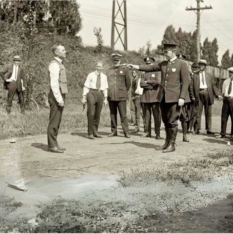 Ez az 1923-as történelmi fotó egy olyan pillanatot örökít meg, amely egyedülálló módon ötvözi a bátorságot és a technológiát: Egy amerikai rendőr mozdulatlanul áll, miközben kollégája közelről éles lőszert céloz a mellkasára, hogy teszteljen egy újonnan kifejlesztett golyóálló mellényt.Abban az időben a lőfegyverek elleni védőruházat még gyerekcipőben járt. Ezek a tesztek egyáltalán nem szimuláció-alapúak voltak – valódi bizalmat igényeltek a mérnöki készségekbe, és ugyanilyen valódi bizalmat a lövő iránt.A kíváncsi pillantásokkal és keresztbe tett karokkal körülvett jelenet szinte olyan, mint egy film – de jól mutatja az akkori biztonsági technológiai fejlesztések komolyságát.Manapság egy tesztlaboratóriumot használnának ilyesmire – akkoriban maga az emberi test volt a tesztterület. Ijesztően realisztikus, mégis jelentős lépés a modern ballisztikus védőfelszerelések felé vezető úton.